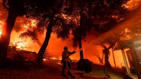 A firefighter battles the Airport Fire, Tuesday, Sept. 10, 2024, in El Cariso, an unincorporated community in Riverside County, Calif. (AP Photo/Etienne Laurent)