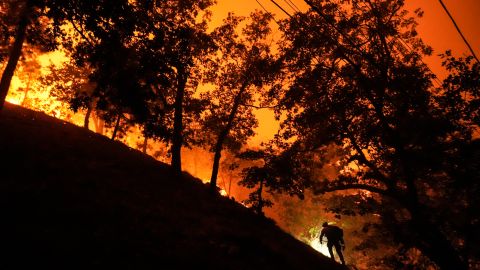 A firefighter is silhouetted against the glow from the Bridge Fire in Wrightwood, Calif., Tuesday, Sept. 10, 2024. (AP Photo/Jae C. Hong)