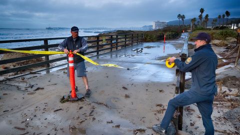 Ventura city workers close off an ocean walk where turbulent surf was hitting on Saturday, Dec. 30, 2023 in Ventura, Calif. Bulldozers built giant sand berms to protect beachfront homes in Ventura, one of California's coastal cities hit hard this week by extraordinary waves generated by powerful swells from Pacific storms. (AP Photo/Richard Vogel)