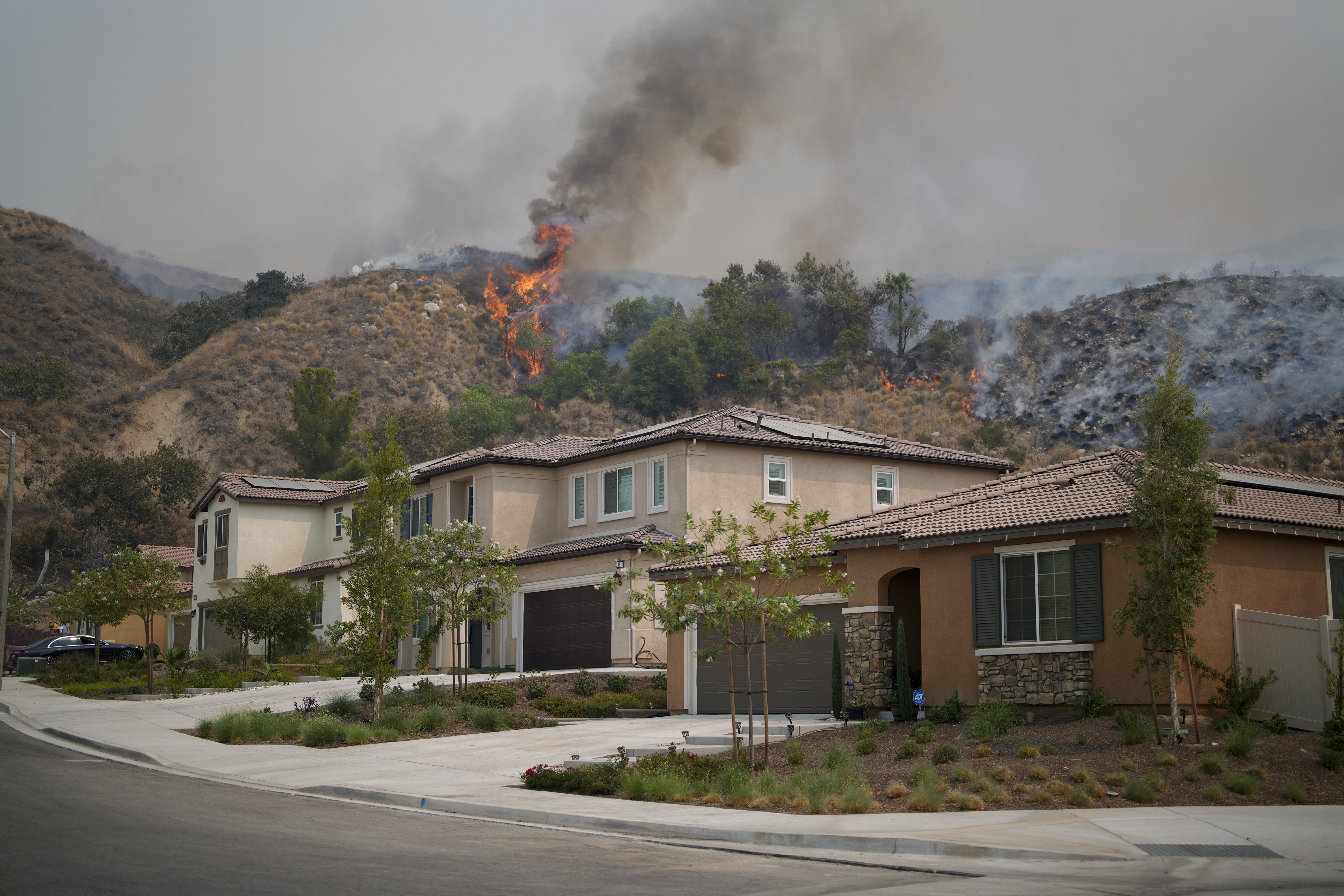 Flames from the Line Fire ignite over a residence Saturday, Sept. 7, 2024, in Highland, Calif. (AP Photo/Eric Thayer)