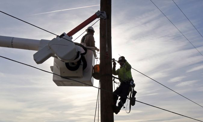 Southern California Edison crews work to replace burned power poles and lines destroyed by the Woolsey Fire over a burned-over hillside along Pacific Coast Highway in Malibu in Southern California Tuesday, Nov. 13, 2018. (AP Photo/Reed Saxon)