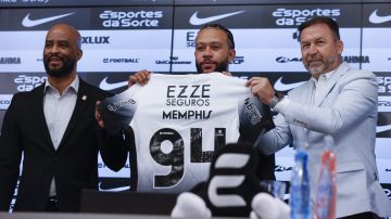 AME8786. SAO PAULO (BRASIL), 12/09/2024.- El futbolista neerlandés Memphis Depay (c), sostiene la camisa del Corinthians durante su presentación como nuevo jugador del club acompañado del presidente del Corinthians Augusto Melo (d) y el manager Fabio Soldado (i), durante una rueda de prensa este jueves en el estadio Neo Química Arena, sede del club Corinthians en Sao Paulo (Brasil). Depay fue recibido como una estrella en el aeropuerto internacional de Guarulhos, en São Paulo, por la afición del Corinthians, en un momento en que el equipo lucha por no descender a segunda división. EFE/ Sebastião Moreira