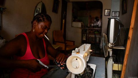 Una costurera espera a que vuelva la luz para seguir con su trabajo este viernes en La Habana.