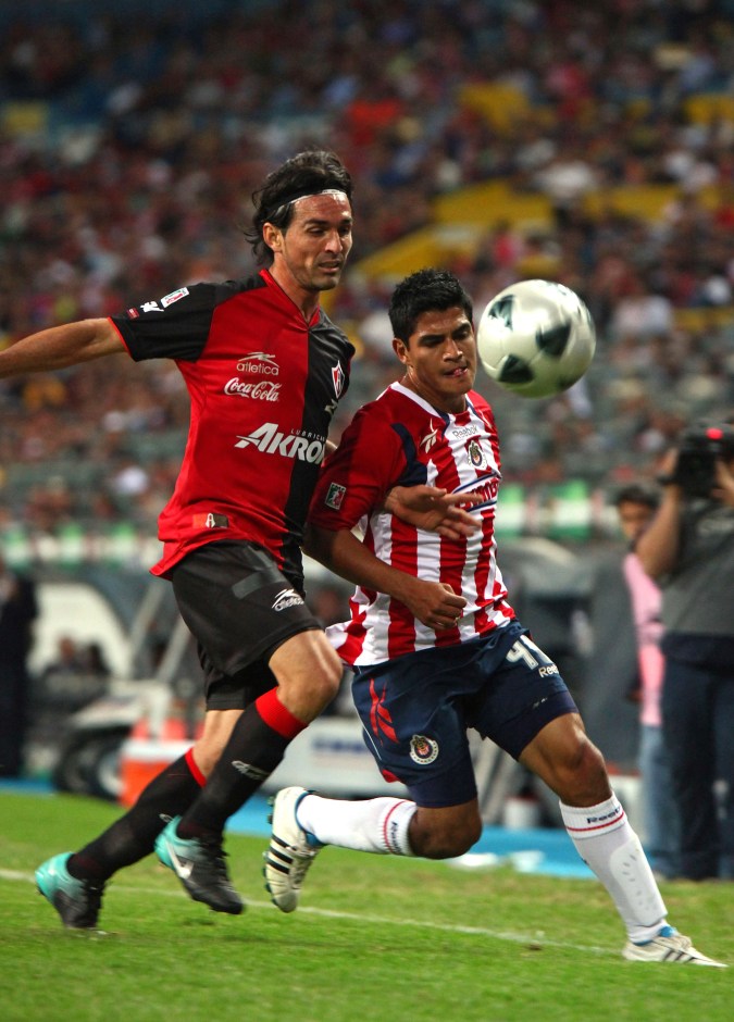 Chivas' Jesus Sanchez, right, fights for the ball with Atlas's Gerardo Espinoza during a Mexican league championship soccer match in Guadalajara, Mexico, Saturday, March 12, 2011. (AP Photo/Bernardo De Niz)