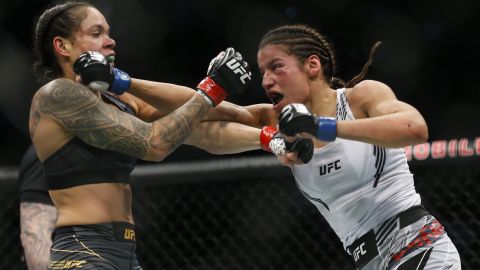 Julianna Pena, right, hits Amanda Nunes during a women's bantamweight mixed martial arts title bout at UFC 269, Saturday, Dec. 11, 2021, in Las Vegas. (AP Photo/Chase Stevens)