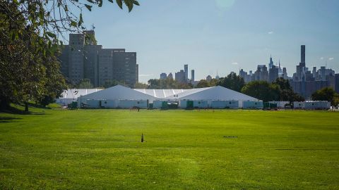 Randall's Island Humanitarian Emergency Response and Relief Center, center, a complex of giant tents, is New York City's latest temporary shelter for an influx of international migrants being bused into the city by southern border states, Oct. 18, 2022, in New York. The shelter will start taking in single adult men on Wednesday, Oct. 19, with facilities including laundry, regular meals and access to international calls. (AP Photo/Bebeto Matthews)