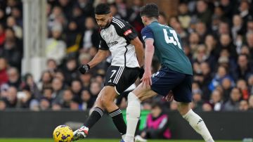 Fulham's Raul Jimenez, left, and Arsenal's Declan Rice vie for the ball during the English Premier League soccer match between Arsenal and Fulham at Craven Cottage stadium in London, Sunday, Dec. 31, 2023. (AP Photo/Alastair Grant)