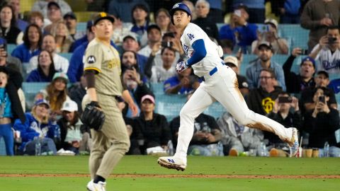 Los Angeles Dodgers' Shohei Ohtani, right, heads to first for a double as San Diego Padres relief pitcher Yuki Matsui watches during the eighth inning of a baseball game, Thursday, Sept. 26, 2024, in Los Angeles. (AP Photo/Mark J. Terrill)