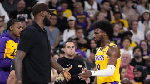 Los Angeles Lakers' LeBron James, left, greets his son, Bronny James as Bronny comes off the court during the first half of a preseason NBA basketball game, Friday, Oct. 4, 2024, in Palm Desert, Calif. (AP Photo/Mark J. Terrill)