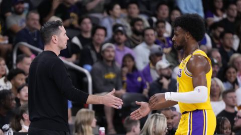 Los Angeles Lakers head coach JJ Redick, left, shakes hands with guard Bronny James as he comes out of the game during the first half of a preseason NBA basketball game against the Minnesota Timberwolves, Friday, Oct. 4, 2024, in Palm Desert, Calif. (AP Photo/Mark J. Terrill)