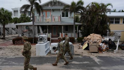 Members of the Florida Army National Guard check for any remaining residents in nearly-deserted Bradenton Beach, where piles of debris from Hurricane Helene flooding still sits outside damaged homes ahead of the arrival of Hurricane Milton, Tuesday, Oct. 8, 2024, on Anna Maria Island, Fla. (AP Photo/Rebecca Blackwell)