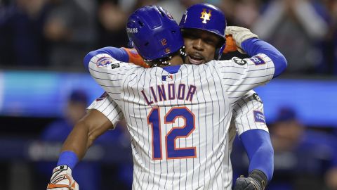 New York Mets' Francisco Lindor (12) hugs Starling Marte (6) after hitting a grand slam home run against the Philadelphia Phillies during the sixth inning of Game 4 of the National League baseball playoff series, Wednesday, Oct. 9, 2024, in New York. (AP Photo/Adam Hunger)