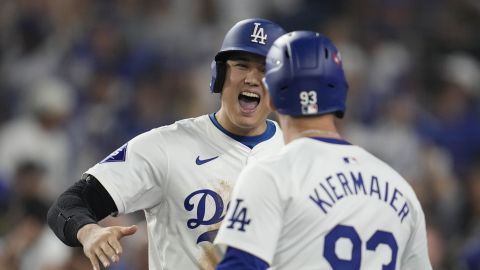 Los Angeles Dodgers' Shohei Ohtani celebrates with Kevin Kiermaier (93) after scoring on a double by Mookie Betts during the eighth inning in Game 1 of a baseball NL Championship Series against the New York Mets, Sunday, Oct. 13, 2024, in Los Angeles. (AP Photo/Ashley Landis)