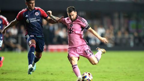 Inter Miami forward Lionel Messi (10) kicks the ball to score a goal as New England Revolution defender Xavier Arreaga, left, defends during the second half of an MLS soccer match, Saturday, Oct. 19, 2024, in Fort Lauderdale, Fla. (AP Photo/Lynne Sladky)