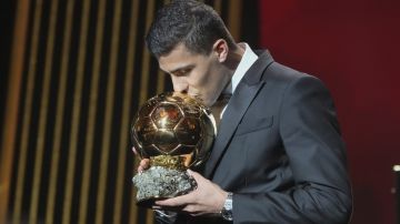 Manchester City's Spanish player Rodri kisses the trophy as he receives the 2024 Men's Ballon d'Or award during the 68th Ballon d'Or (Golden Ball) award ceremony at Theatre du Chatelet in Paris, Monday, Oct. 28, 2024. (AP Photo/Michel Euler)