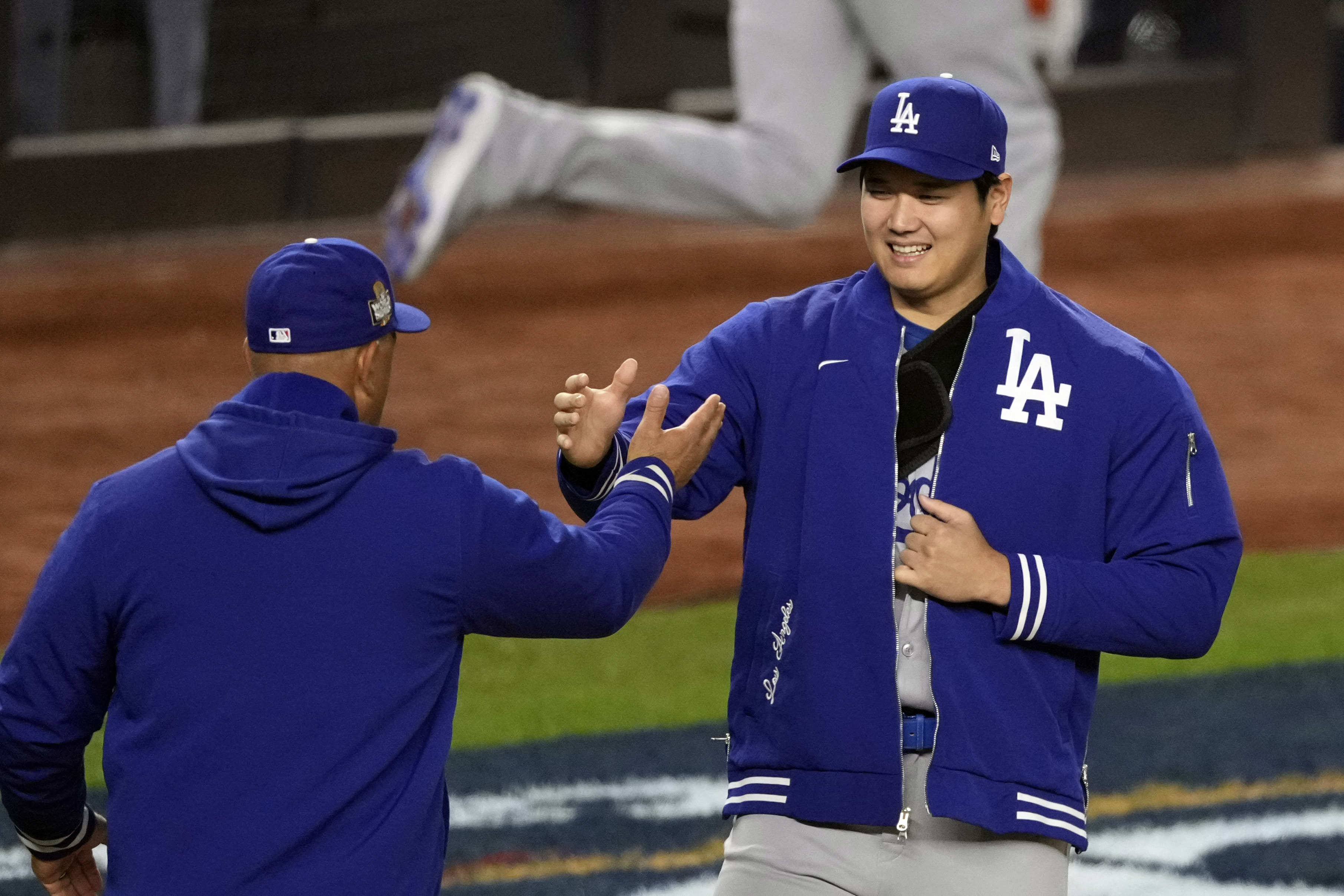 Shohei Ohtani saluda a su manager Dave Roberts durante la introducción de jugadores para el juego 3 de la Serie Mundial. El japonés inició a pesar de una lesión sufrida en el juego previo.