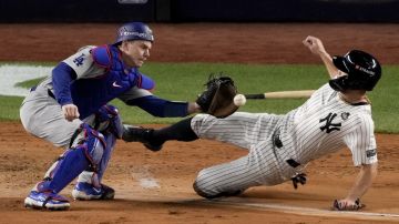 El catcher de los Dodgers, Will Smith, pone out en home al corredor Giancarlo Stanton, de los Yankees, gracias al gran tiro del jardinero Teoscar Hernández en el juego 3 de la Serie Mundial.