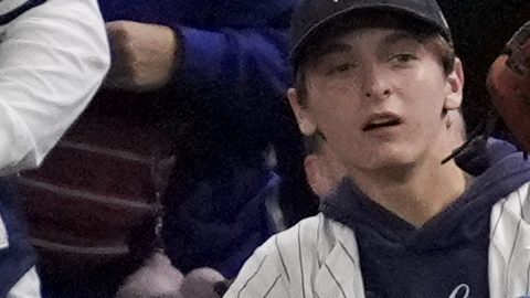 Fans interfere with a foul ball caught by Los Angeles Dodgers right fielder Mookie Betts during the first inning in Game 4 of the baseball World Series against the New York Yankees, Tuesday, Oct. 29, 2024, in New York. (AP Photo/Ashley Landis)