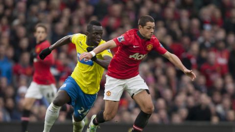 Manchester United's Javier Hernandez keeps the ball from Newcastle's Cheik Ismael Tiote during their English Premier League soccer match at Old Trafford Stadium, Manchester, England, Saturday Dec. 7, 2013. (AP Photo/Jon Super)