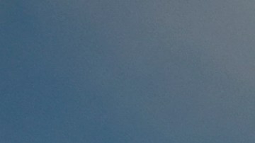 A firefighter works on hotspots as a helicopter prepares to drop water on a wildfire in Castaic, Calif. on Wednesday, Aug. 31, 2022. (AP Photo/Ringo H.W. Chiu)