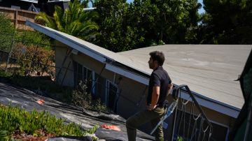 FILE - A reporter stands near a home that collapsed due to ongoing landslides in Rancho Palos Verdes, Calif., Tuesday, Sept. 3, 2024. (AP Photo/Jae C. Hong, File)