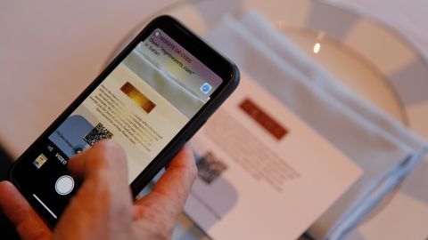 Bill Hornbuckle, acting CEO and president of MGM Resorts International, demonstrates a QR code menu at Prime Steakhouse in the Bellagio hotel and casino, Wednesday, May 20, 2020, in Las Vegas. Casino operators in Las Vegas are awaiting word when they will be able to reopen after a shutdown during the coronavirus outbreak. (AP Photo/John Locher)