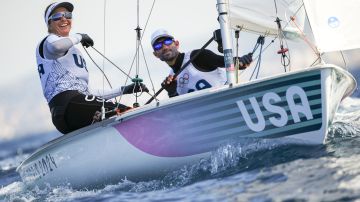 Lara Dallman-Weiss and Stuart McNay of the United States make their way to the start of the mixed dinghy race during the 2024 Summer Olympics, Sunday, Aug. 4, 2024, in Marseille, France. (AP Photo/Daniel Cole)