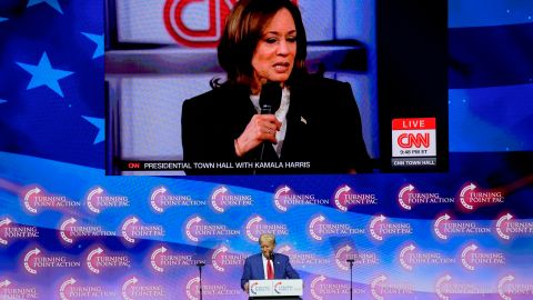 A video plays of Democratic presidential nominee Vice President Kamala Harris speaking during a town hall as Republican presidential nominee former President Donald Trump listens during a campaign rally at Thomas & Mack Center, Thursday, Oct. 24, 2024, in Las Vegas. (AP Photo/John Locher)