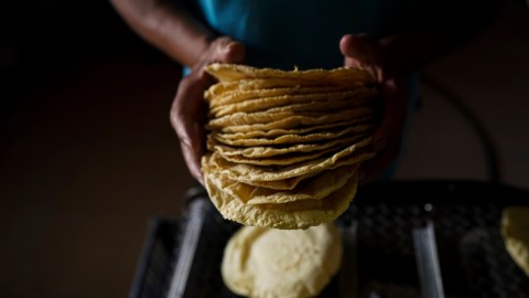 A worker packages tortillas to sell for 20 Mexican Pesos per kilogram, about one dollar, at a tortilla factory in Mexico City, Monday, May 9, 2022. Almost a year ago the same tortilla factory used to sell a kilo of tortillas for 10 Mexican Pesos. (AP Photo/Fernando Llano)