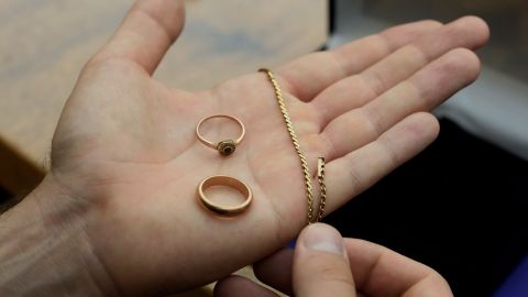 A relative shows golden jewelry that was confiscated by Nazi Germans from Zofia Strusińska and her sister Józefa Skórka, who were captured by Nazi troops during Warsaw Uprising in 1944 and taken to a forced labor camp. Their seized items that had been stored at Germany's Arolsen Archives, were returned to their relatives in a ceremony in Warsaw, Poland, on Tuesday, Sept. 10, 2024, in which 10 other families also had belongings of their relatives returned. (AP Photo/Czarek Sokolowski)