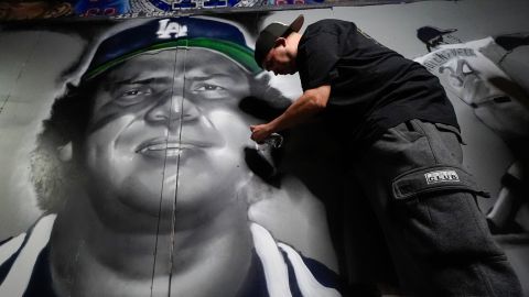 Artist Louie Palestino works on a mural depicting former Los Angeles Dodgers pitcher Fernando Valenzuela, Wednesday, Oct. 23, 2024 in North Hollywood, Calif. Valenzuela, the Mexican-born phenom for the Los Angeles Dodgers who inspired "Fernandomania" while winning the NL Cy Young Award and Rookie of the Year in 1981, died Tuesday, Oct. 22, 2024. (AP Photo/Julio Cortez)