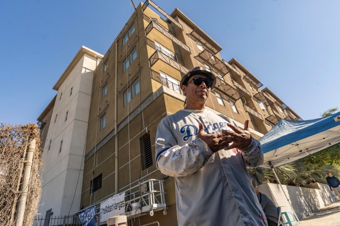 Mural artist Robert Vargas, a Boyle Heights native, gets his team ready to start painting a mural to honor former Dodgers pitcher Fernando Valenzuela on the side of a building in Boyle Heights neighborhood of Los Angeles on Wednesday, Oct. 23, 2024, Valenzuela, the Mexican-born phenom for the Los Angeles Dodgers who inspired "Fernandomania" while winning the NL Cy Young Award and Rookie of the Year in 1981, died Tuesday, Oct. 22, 2024. (AP Photo/Damian Dovarganes)