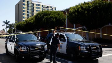 Long Beach police keep a street closed off near a retirement home, seen in background on Monday, June 25, 2018, in Long Beach, Calif. A resident of a retirement home in Southern California opened fire on firefighters responding to a report of an explosion in the building, killing at least one and wounding others, officials said. (AP Photo/Jae C. Hong)