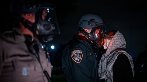 A pro-Palestinian protester confronts police as demonstrators clash at an encampment at UCLA Wednesday, May 1, 2024, in Los Angeles. Dueling groups of protesters have clashed at the University of California, Los Angeles, grappling in fistfights and shoving, kicking and using sticks to beat one another. (AP Photo/Ethan Swope)