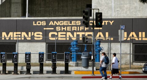 FILE - In this Sept. 28, 2011 photo, people walk past the Los Angeles County Sheriff's Men's Central Jail facility in Los Angeles. A federal judge has given initial approval to an agreement that requires the Los Angeles County Sheriffs Department to improve conditions in its jails for inmates using wheelchairs and others with mobility impairments. (AP Photo/Damian Dovarganes, File)