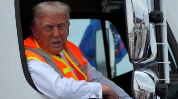 Trump habla con periodistas mientras está sentado en un camión de basura en Green Bay, Wisconsin.