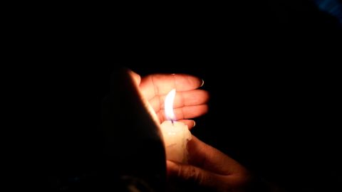 A woman holds a candle during a march on Reforma Avenue towards the senate to protest the president's proposal to move the nominally civilian National Guard under the operational and administrative control of the Defense Ministry, in Mexico City, Tuesday, Sept. 6, 2022. The proposal passed Mexico's lower chamber last week and has raised concerns about the militarization of Mexico's security. (AP Photo/Eduardo Verdugo)