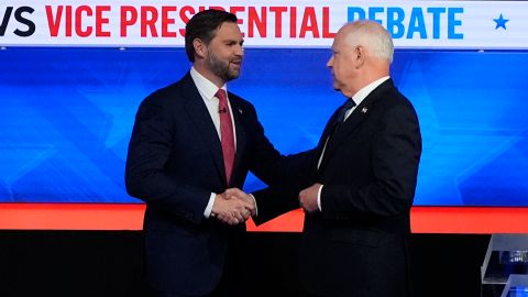 El senador J.D. Vance, a la izquierda, y el gobernador de Minnesota, Tim Walz, se dan la mano al llegar al debate vicepresidencial.