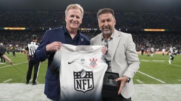 El comisionado de la NFL Roger Goodell posa junto a Augusto Melo, del Corinthians, durante el juego de la liga estadounidense en Brasil.