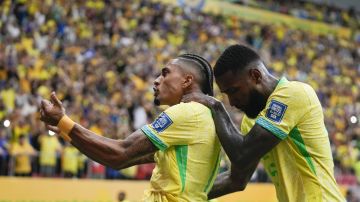 Brazil's Raphinha, left, celebrates after scoring his side's second goal from the penalty spot against Peru during a qualifying soccer match for the FIFA World Cup 2026 at Mane Garrincha Stadium in Brasilia, Brazil, Tuesday, Oct. 15, 2024. (AP Photo/Eraldo Peres)