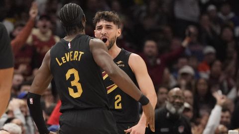 Cleveland Cavaliers guard Ty Jerome, right, celebrates a three-point basket with teammate Caris LeVert (3) in the first half of an NBA basketball game against the Golden State Warriors, Friday, Nov. 8, 2024, in Cleveland. (AP Photo/Sue Ogrocki)