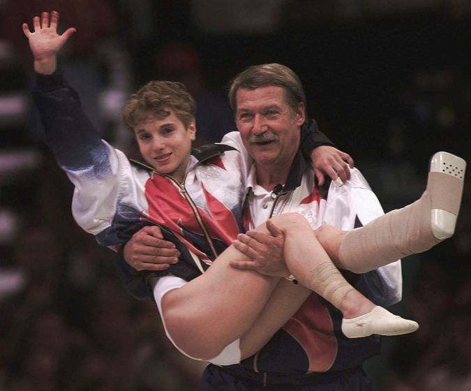 La gimasta estadounidense Kerri Strug es cargada en brazos por el entrenador, Bela Karolyi en una famosa imagen de los Juegos Olímpicos de 1996 tras competir lesionada y ayudar a EE.UU. a ganar el oro por equipos.