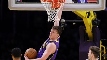 Los Angeles Lakers guard Dalton Knecht dunks during the first half of an Emirates NBA Cup basketball game agaianst the Utah Jazz, Tuesday, Nov. 19, 2024, in Los Angeles. (AP Photo/Etienne Laurent)