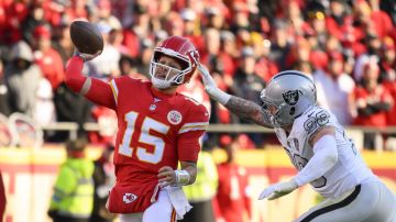 Kansas City Chiefs quarterback Patrick Mahomes (15) is chased by Las Vegas Raiders defensive end Maxx Crosby (98) during the first half of an NFL football game, Friday, Nov. 29, 2024 in Kansas City, Mo. (AP Photo/Reed Hoffmann)