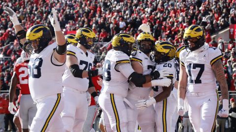 Jugadores de la Universidad de Michigan celebran durante el partido de rivalidad contra Ohio State en Columbus. El juego terminó con una pelea masiva.