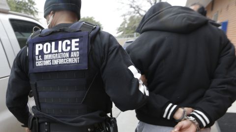 In this photo made Thursday, March 6, 2015, a U.S. Immigration and Customs Enforcement agent escorts a handcuffed undocumented immigrant convicted of a felony that was taken into custody during an early morning operation in Dallas. The Department of Homeland Security has been conducting a nationwide roundup of undocumented immigrants convicted of felonies in order to deport them to their country of origin. (AP Photo/LM Otero)