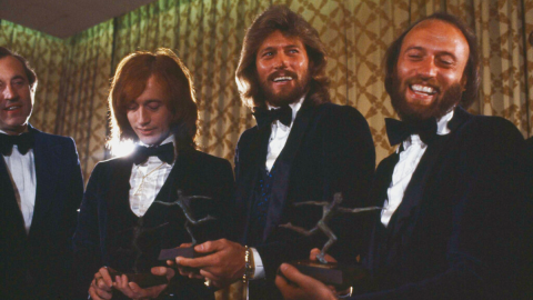 Robin, Barry and Maurice Gibb (left to right), collectively known as the Bee Gees, are pictured in New York, Feb. 8, 1979. Man at far left is unidentified. (AP Photo/Richard Drew)