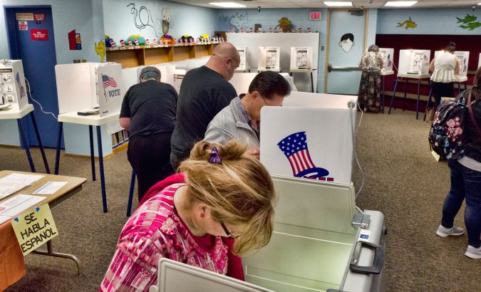 FILE - In this June 5, 2018, file photo, voters mark ballots at a polling place in the library at the Robert F. Kennedy Elementary School in Los Angeles. Californians start voting Monday, Feb. 3, 2020, in a high-profile Democratic presidential primary that has no clear front-runner. For the first time, Californians can register to vote on election day at the polls. (AP Photo/Richard Vogel, File)