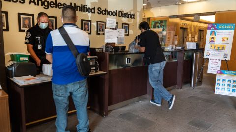 Visitors wait in line to be screened by security before being allowed to enter the Los Angeles Unified School District administrative offices in Los Angeles Thursday Sept. 9, 2021. The Los Angeles board of education is expected to vote Thursday, on whether to require all students 12 and older to be fully vaccinated against the coronavirus to participate in on-campus instruction in the nation's second-largest school district. (AP Photo/Damian Dovarganes)