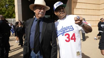 Actor James Olmos, left, poses with a Los Angeles Dodgers fan after a public funeral mass for former Los Angeles Dodger pitcher Fernando Valenzuela at the Cathedral of Our Lady of the Angels in Los Angeles on Wednesday, Nov. 6, 2024. (AP Photo/Damian Dovarganes)